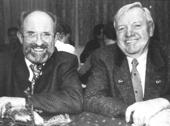 Schwarz-weiss-Foto zweier lächelnder Männer im Anzug